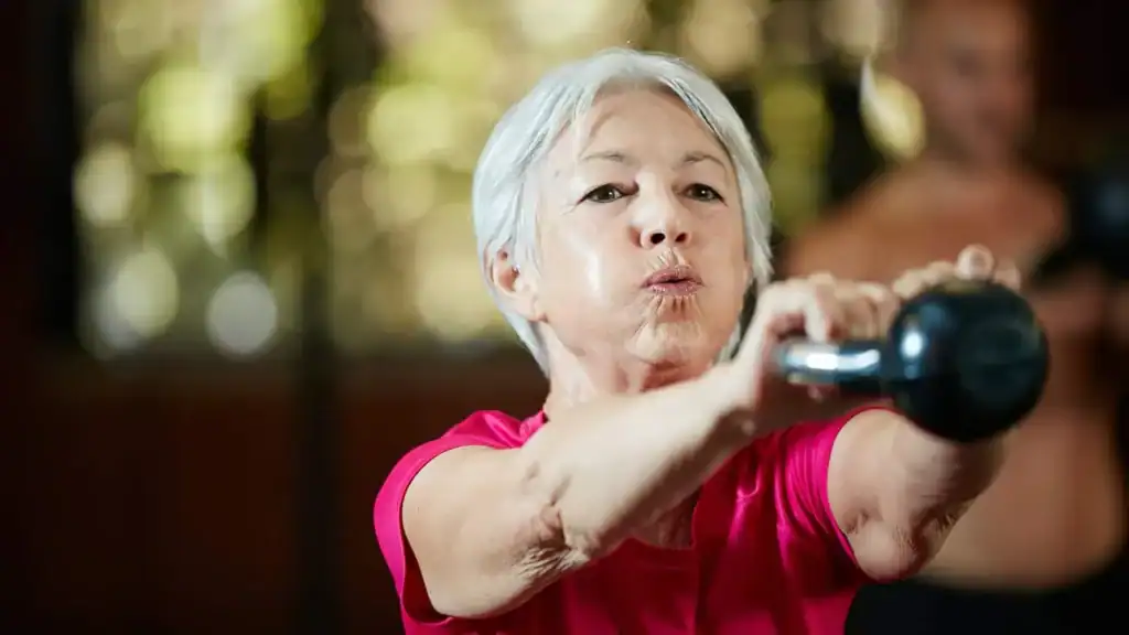Older woman doing weight training Haverhill to help her strength and longevity 