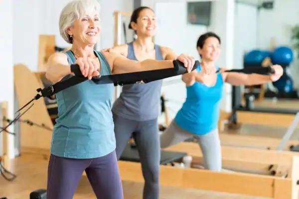 Toning Arms After 60: Empowering Womens Fitness Through Effective Weight Training 2 older woman doing weight training Haverhill and resistance in the gym to tone upper arms