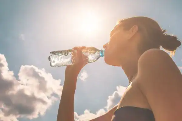Hydration: The Secret Ingredient for a Toned Stomach and Enhanced Fitness 3 Image of woman drinking water to hydrate Haverhill after run.