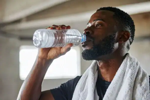 Hydration: The Secret Ingredient for a Toned Stomach and Enhanced Fitness 1 Image of man drinking water to improve hydration Haverhill after work out.